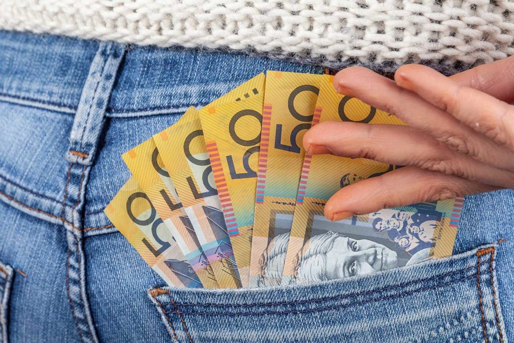 Woman Placing $50 Notes Into Back Jean Pocket