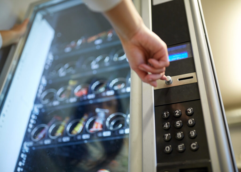 Women pressing button on vending machine